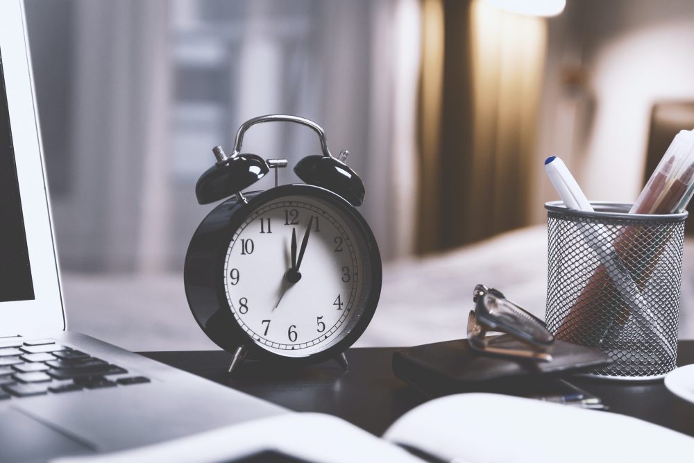 Laptop and clock on table