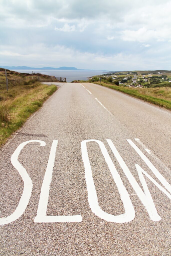 road stretching to the horizon with SLOW painted across the pavement