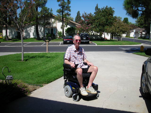 Charles sits in a chair that aids mobility.