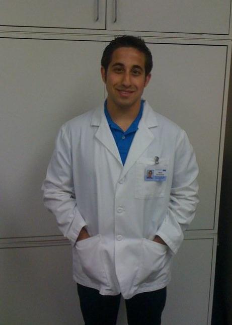 Mike stands wearing a white coat.