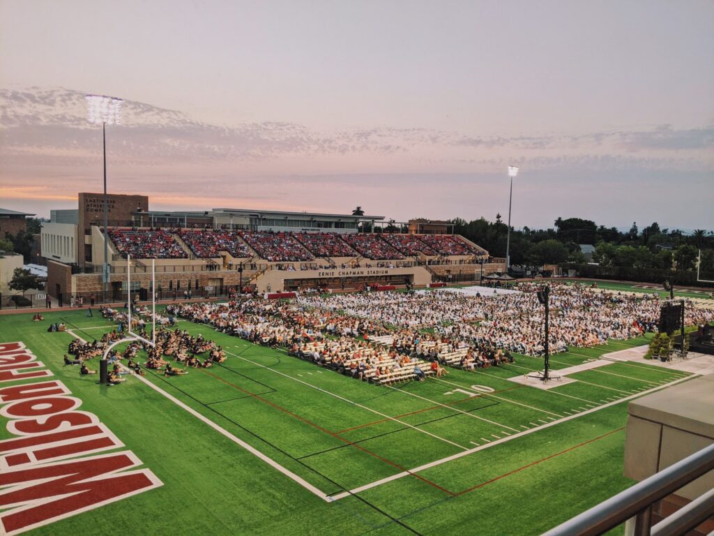 wide shot of ernie chapman statidum at sunset with crowd sitting on field and in stands