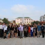 group of students in front of lake