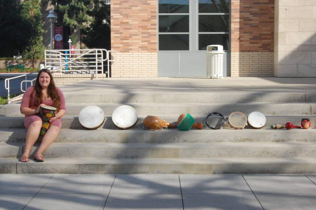student with many different drums