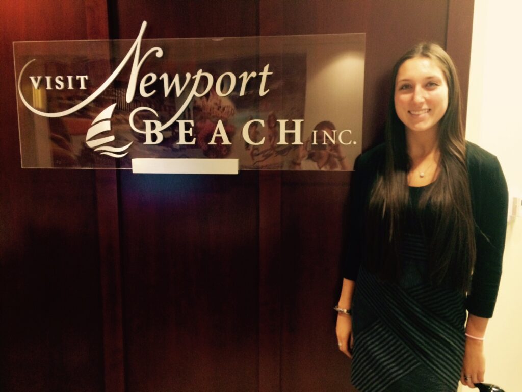 Student next to Newport Beach Inc. sign