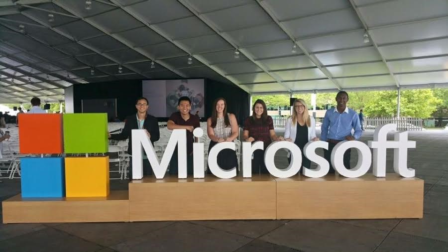 student in front of Microsoft logo sign