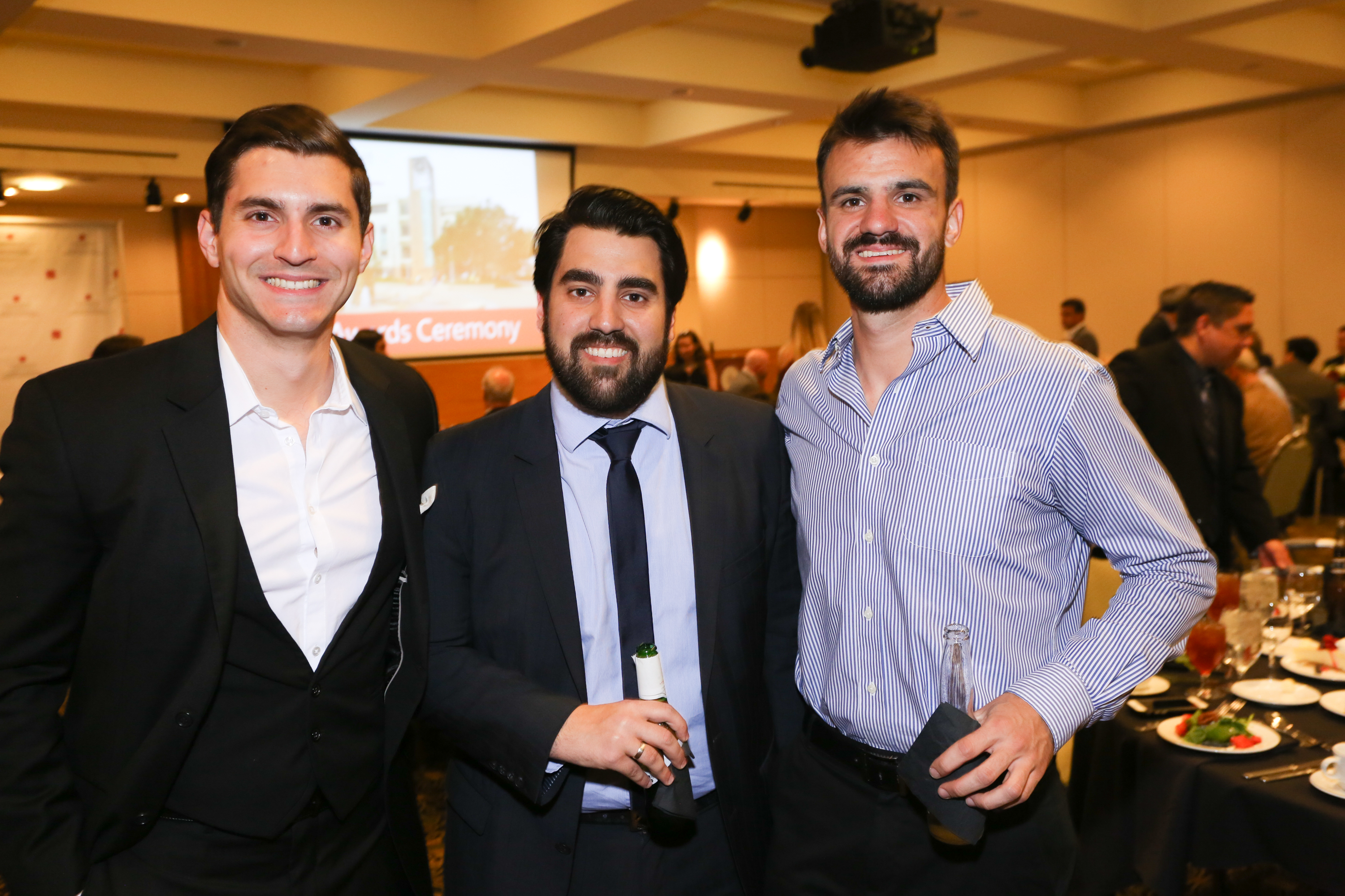 Three male students smiling for photograph