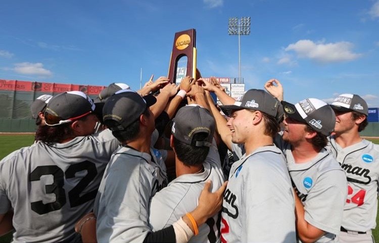 Team gathered around lifted up national championship trophy