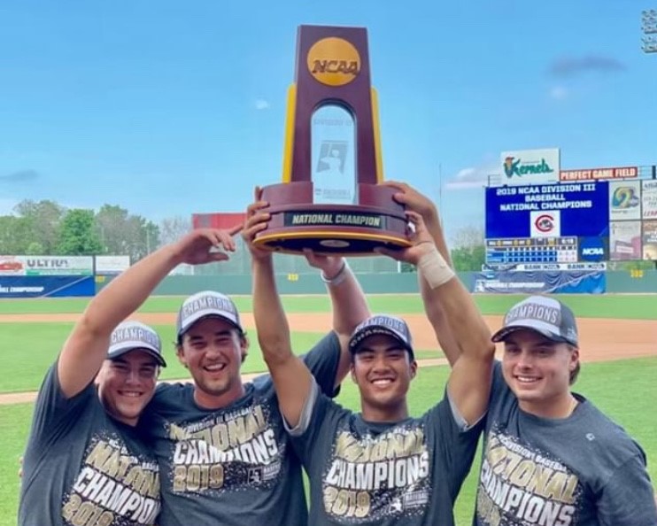Four Chapman baseball players hold up national championship trophy