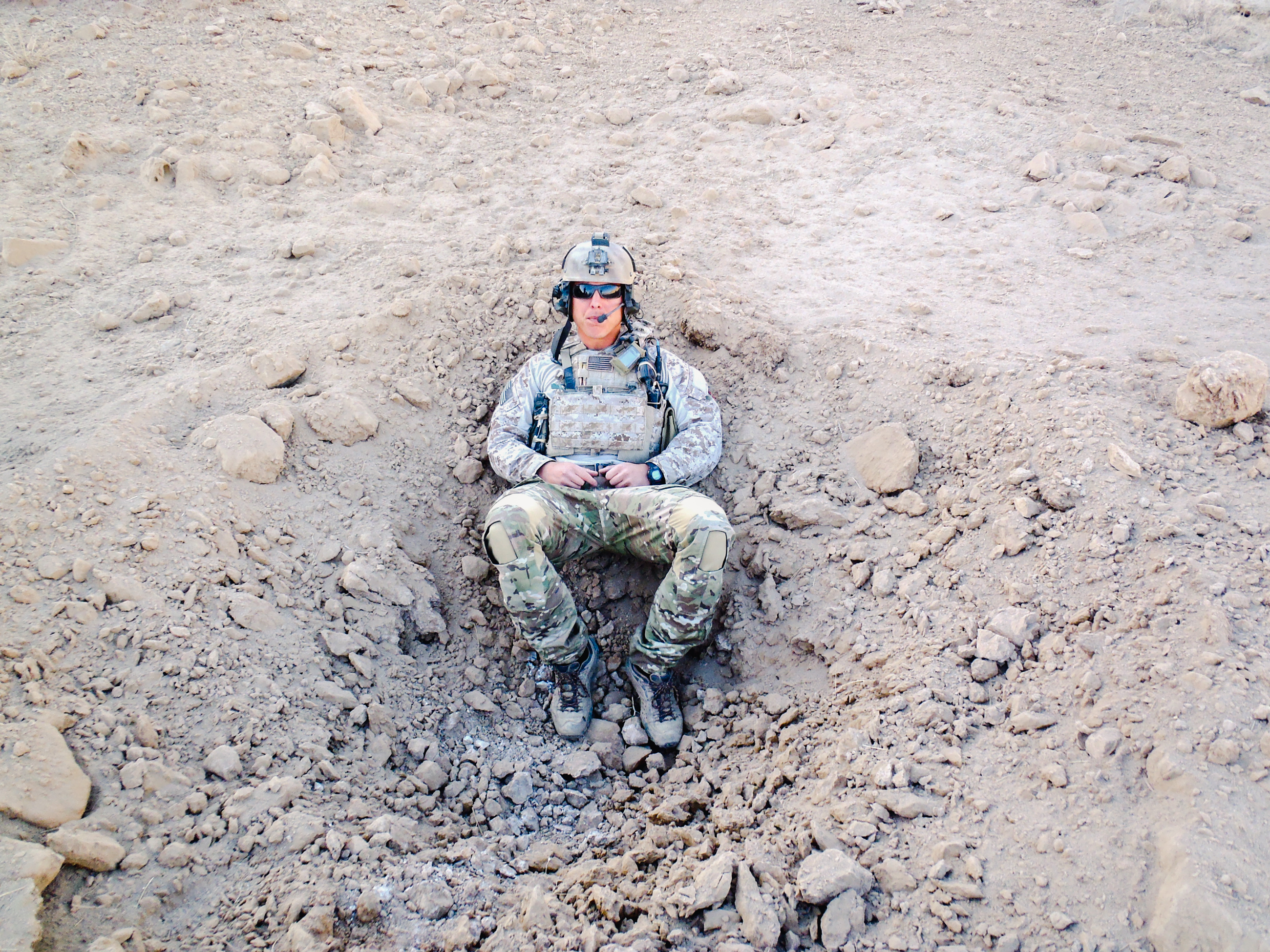 Travis Kennedy in military gear and clothing, seated