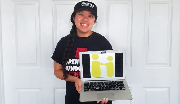 student holding laptop with handshake logo on it