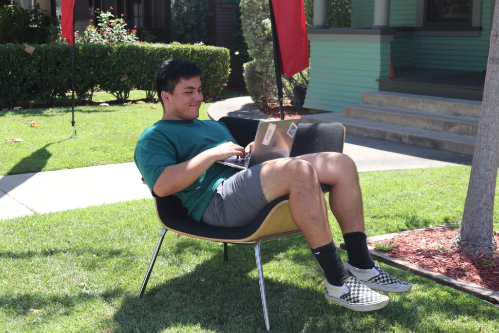 peer advisor rolando is updating his resume during summer break outside