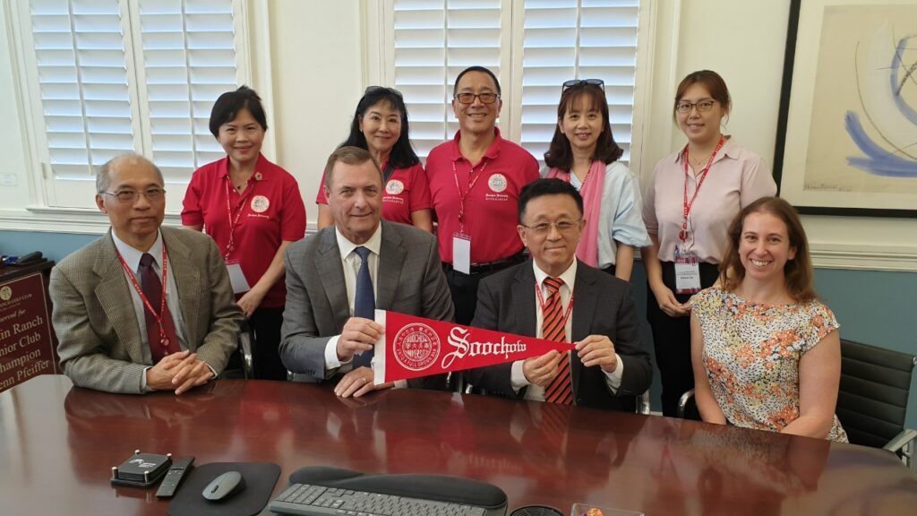 Soochow visitors holding Soochow banner with Dean Price and Assistant Director Jodi Hicks