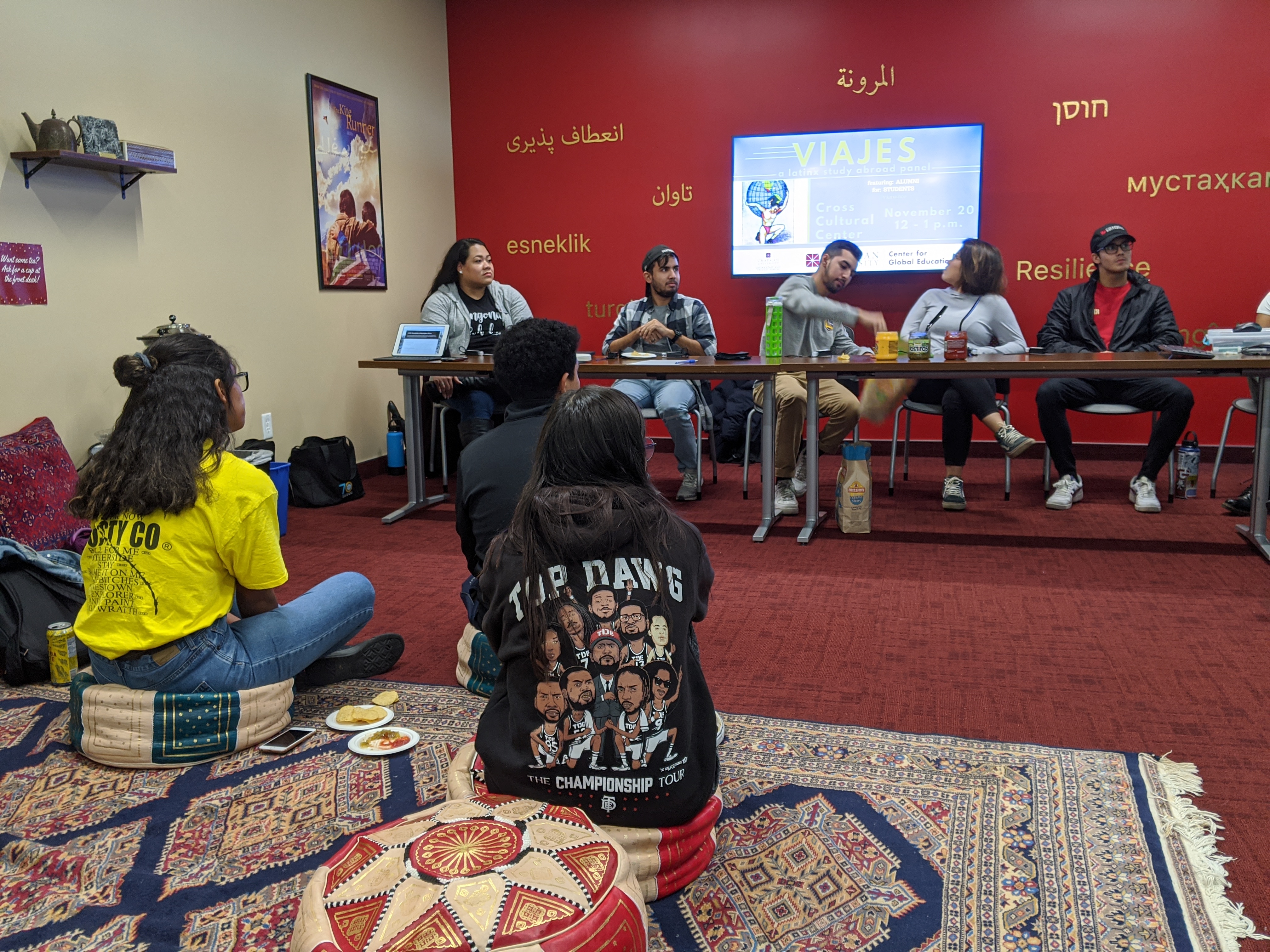 Panelists eating and students listening at Viajes 19 - a LatinX study abroad panel