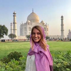 Caroline standing in front of temple with open grass field.