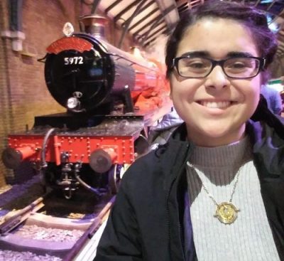 Talia standing to the side of the train to Hogwartz.