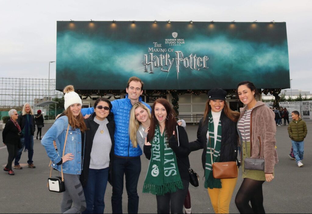 Talia witha group of friends in front of a Harry Potter billboard.