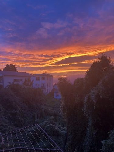 Sunset with some cloads nestled inbetween a valley of mountains.