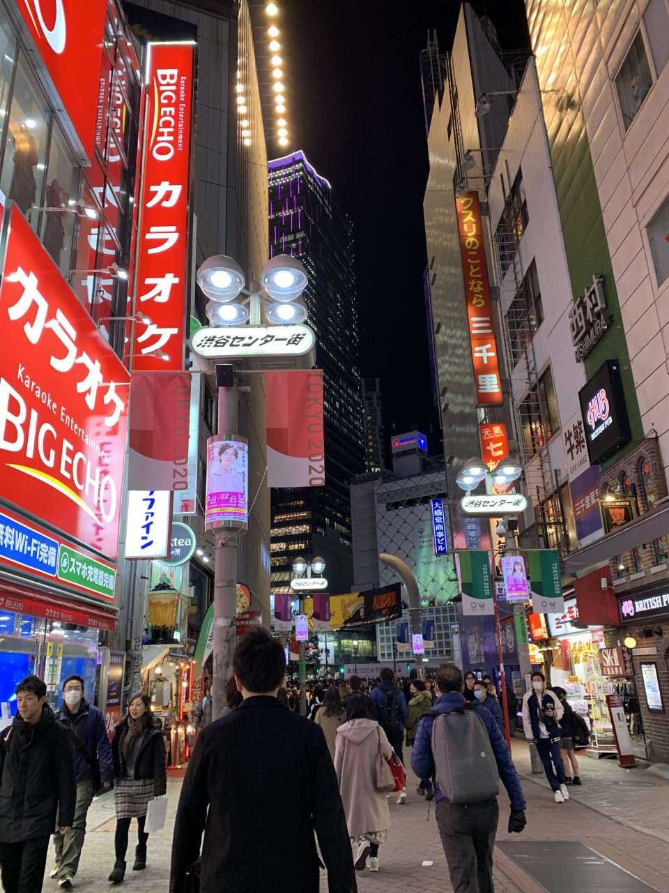 Nightime downtown area of Japan with many advertisements, bright lights, and signs.