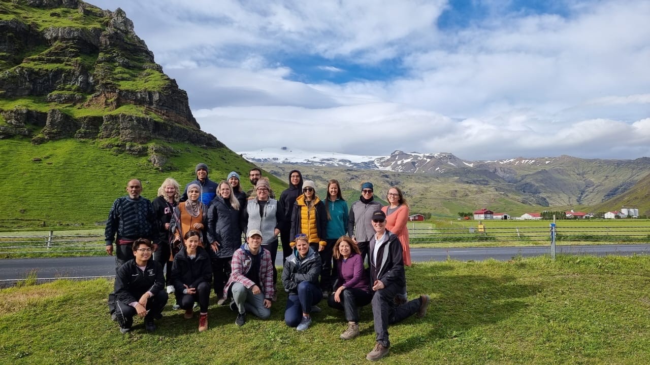 Students in front of hills and a road in Iceland