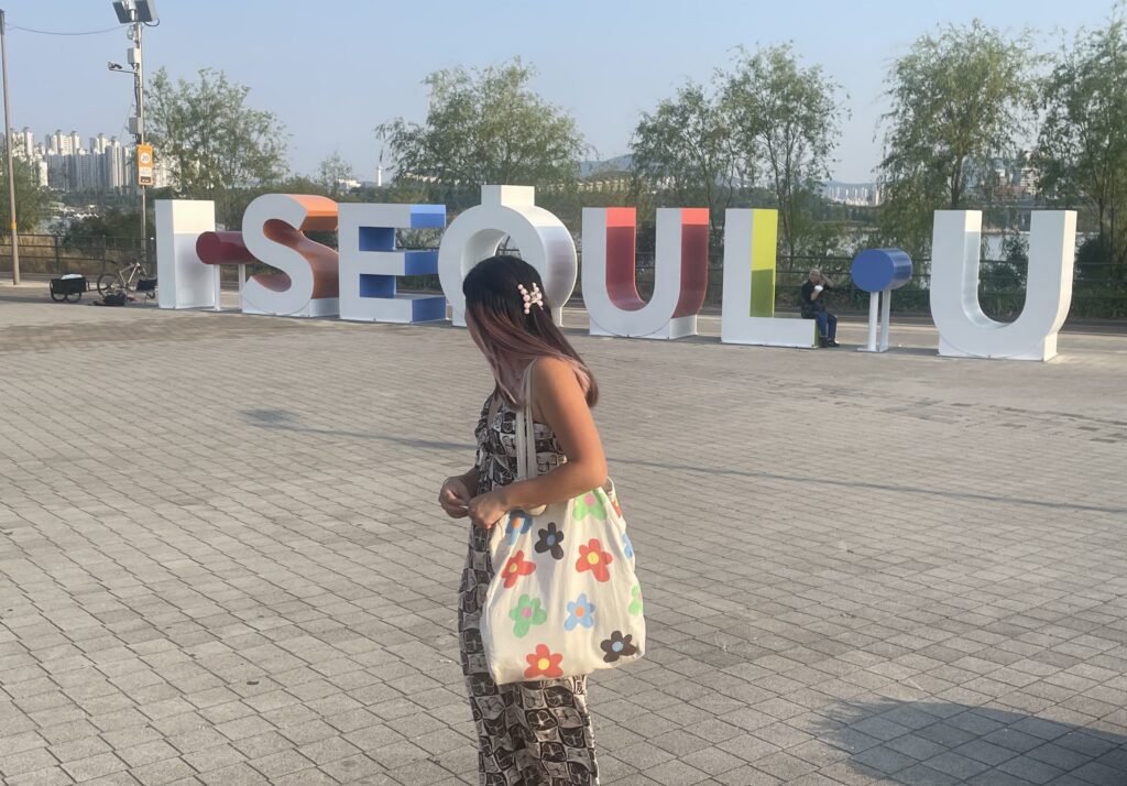student looking back at sign in south korea