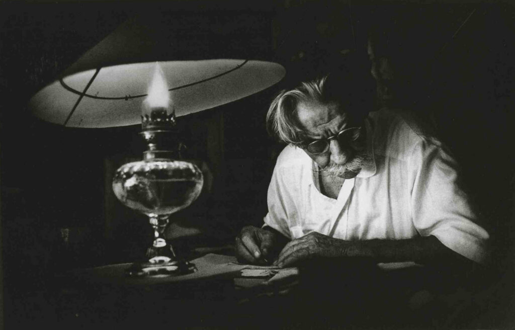black and white photo of man writing