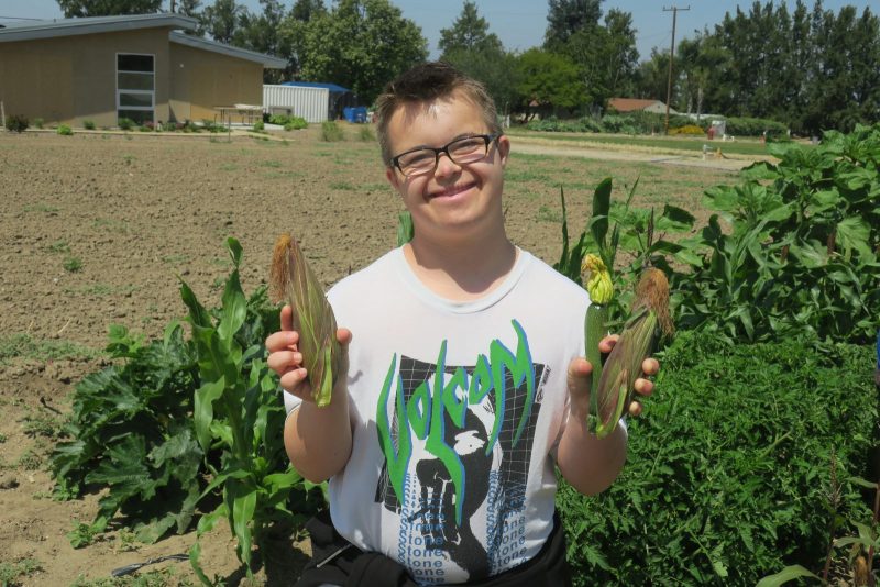 Student at Orange High School holds up produce