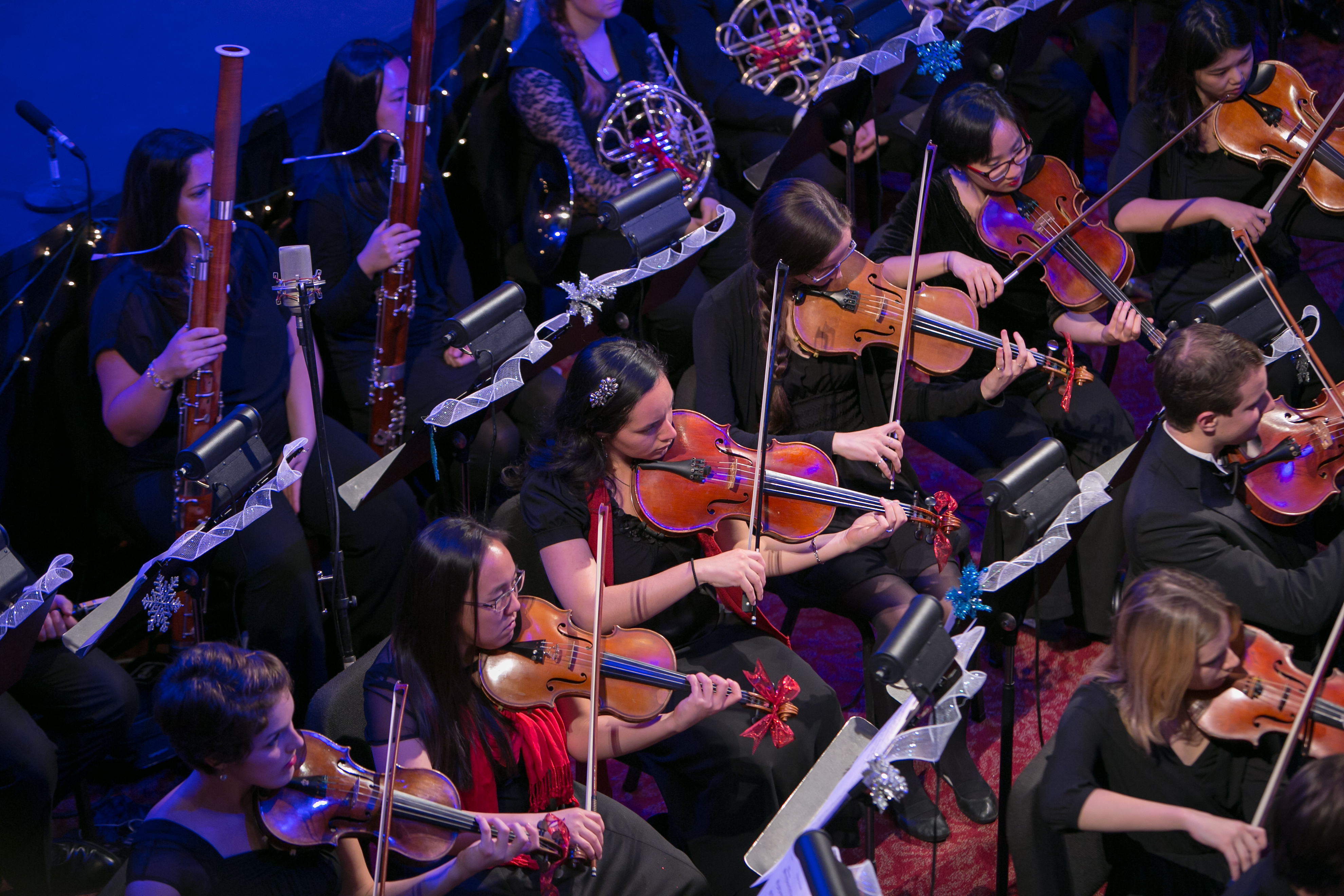 Orchestra playing music, focus on strings.