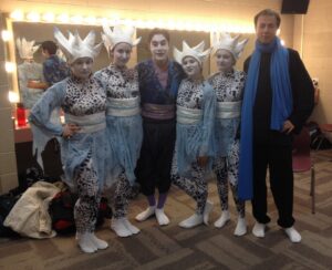 Students pose backstage in costumes at festival.