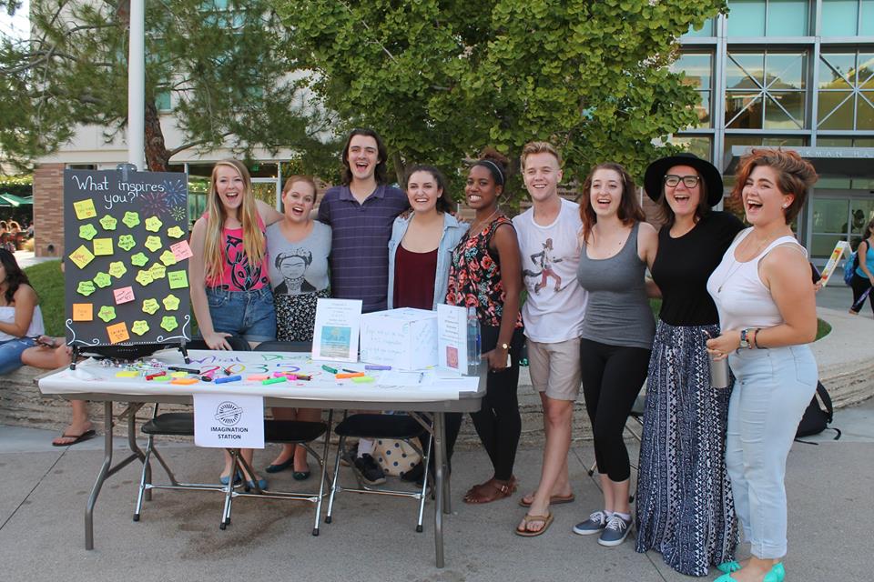 Students stand at an information table.