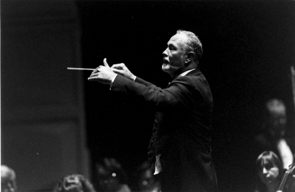 William Hall conducting dressed in a tuxedo.