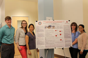 Students stands with research board