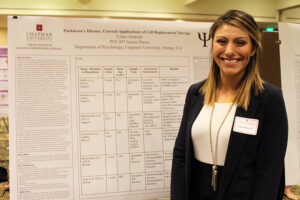 Student stands with research board