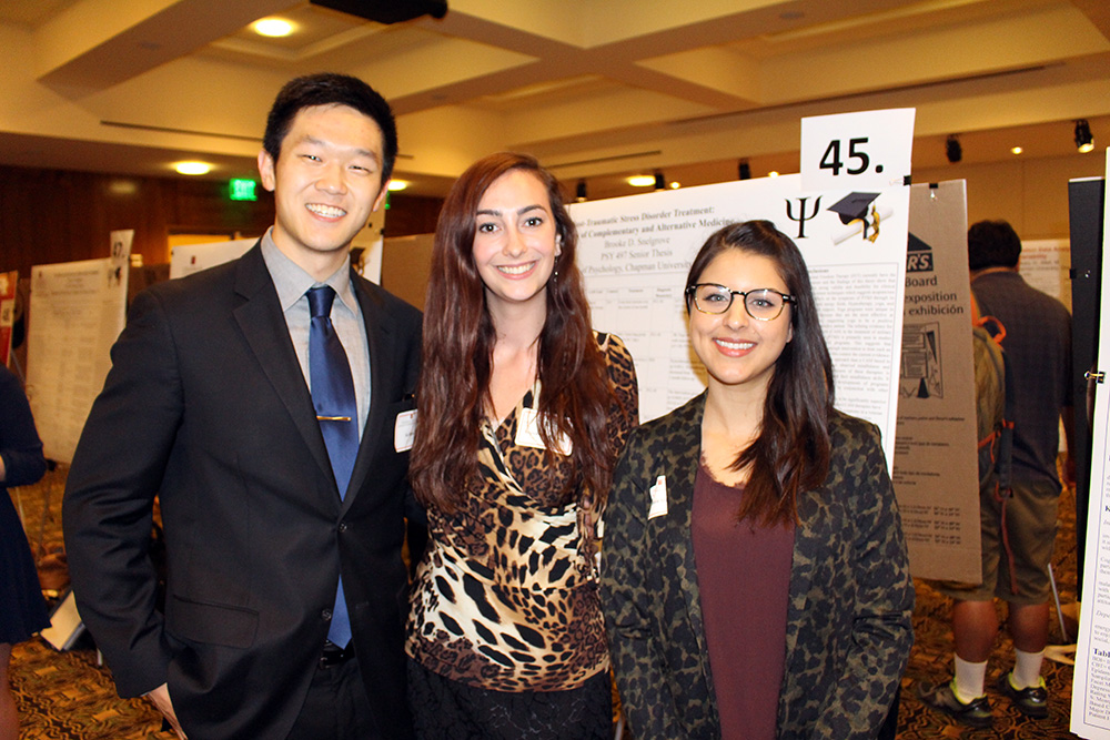 Student stands with research board