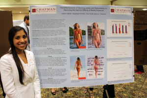 Student stands with research board