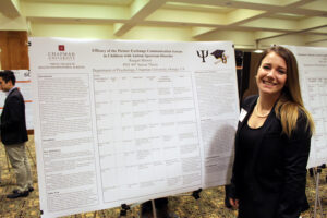 Student stands with research board
