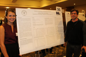 Student stands with research board