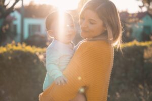 Jessie Ginsburg Holding Baby in Sunlight