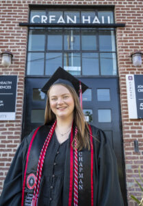 Sarah Rightmire in Graduation Attire in front of Crean Hall.