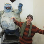 Digital Arts student poses in front of character statue