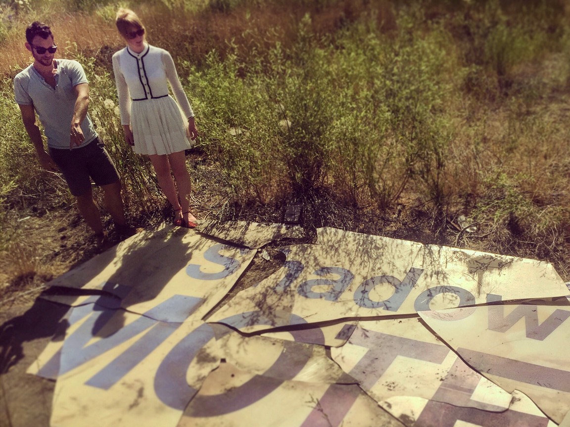shadow motel sign with actors standing on it