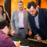 man signing at first cut
