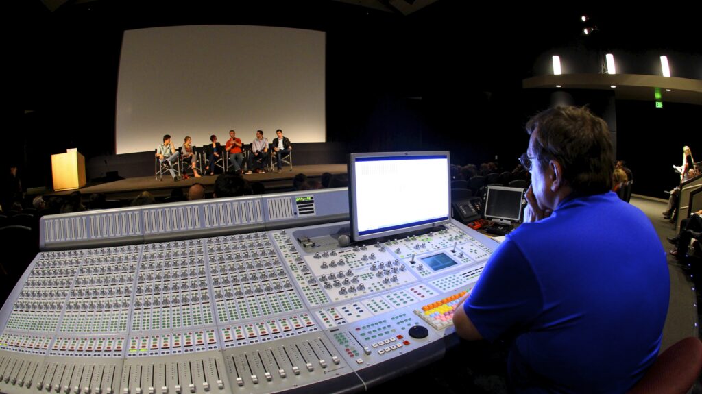 man sitting at sound board during presentation