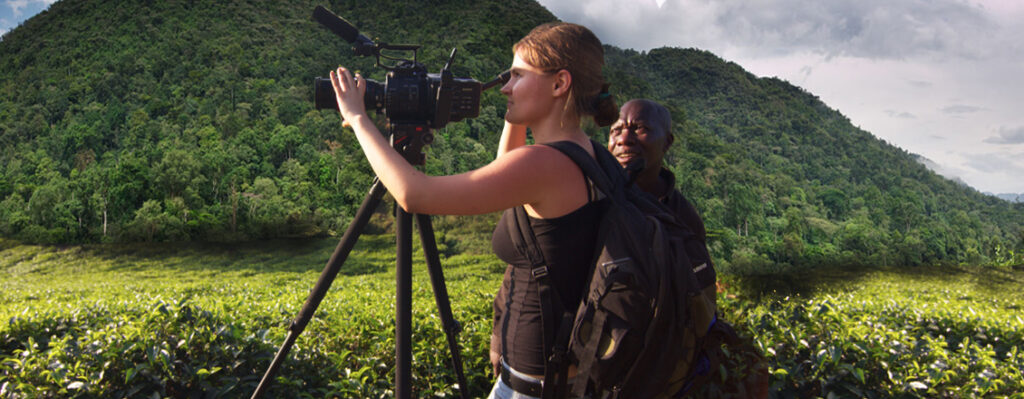 student framing camera in tropical landscape