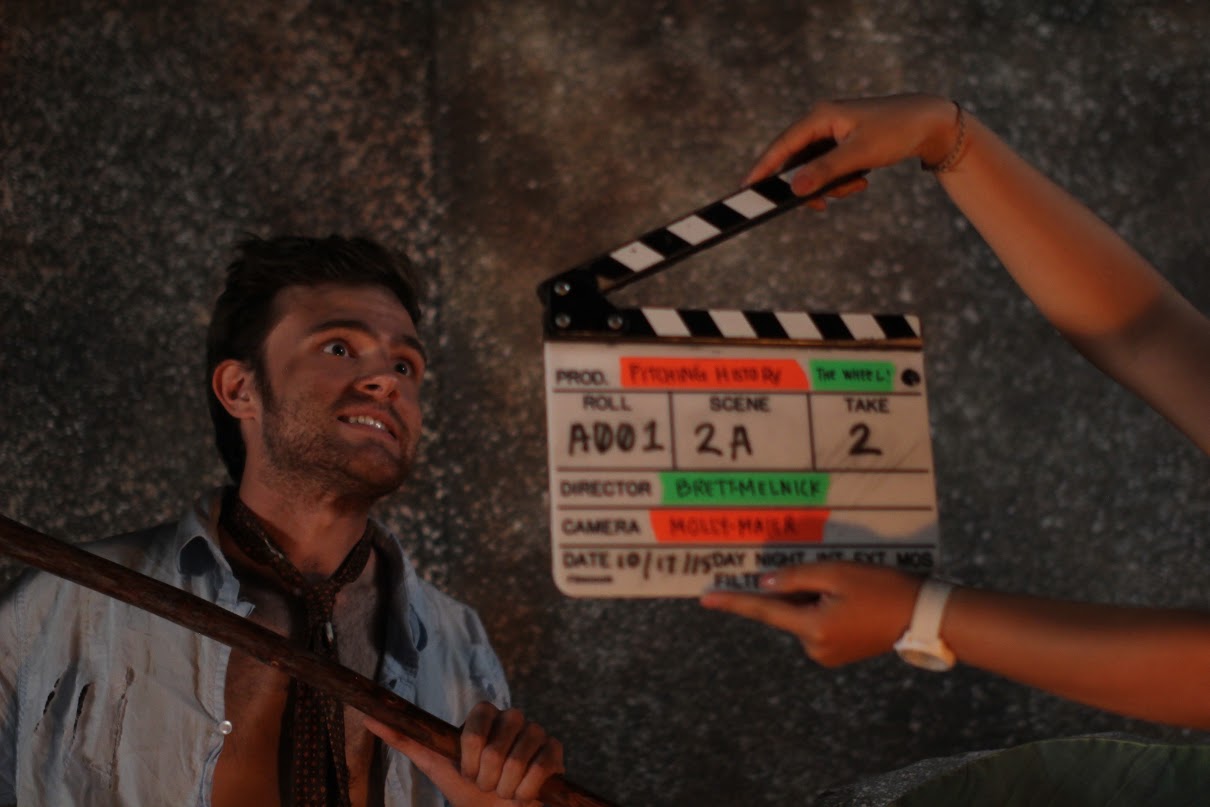man with crazed look and clap board