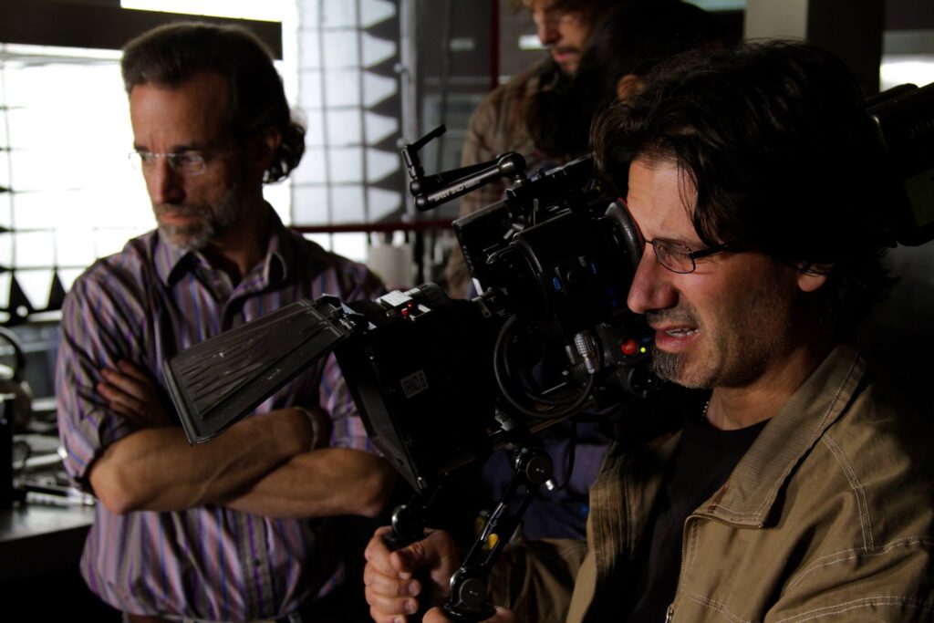 man holding camera while someone else looks on