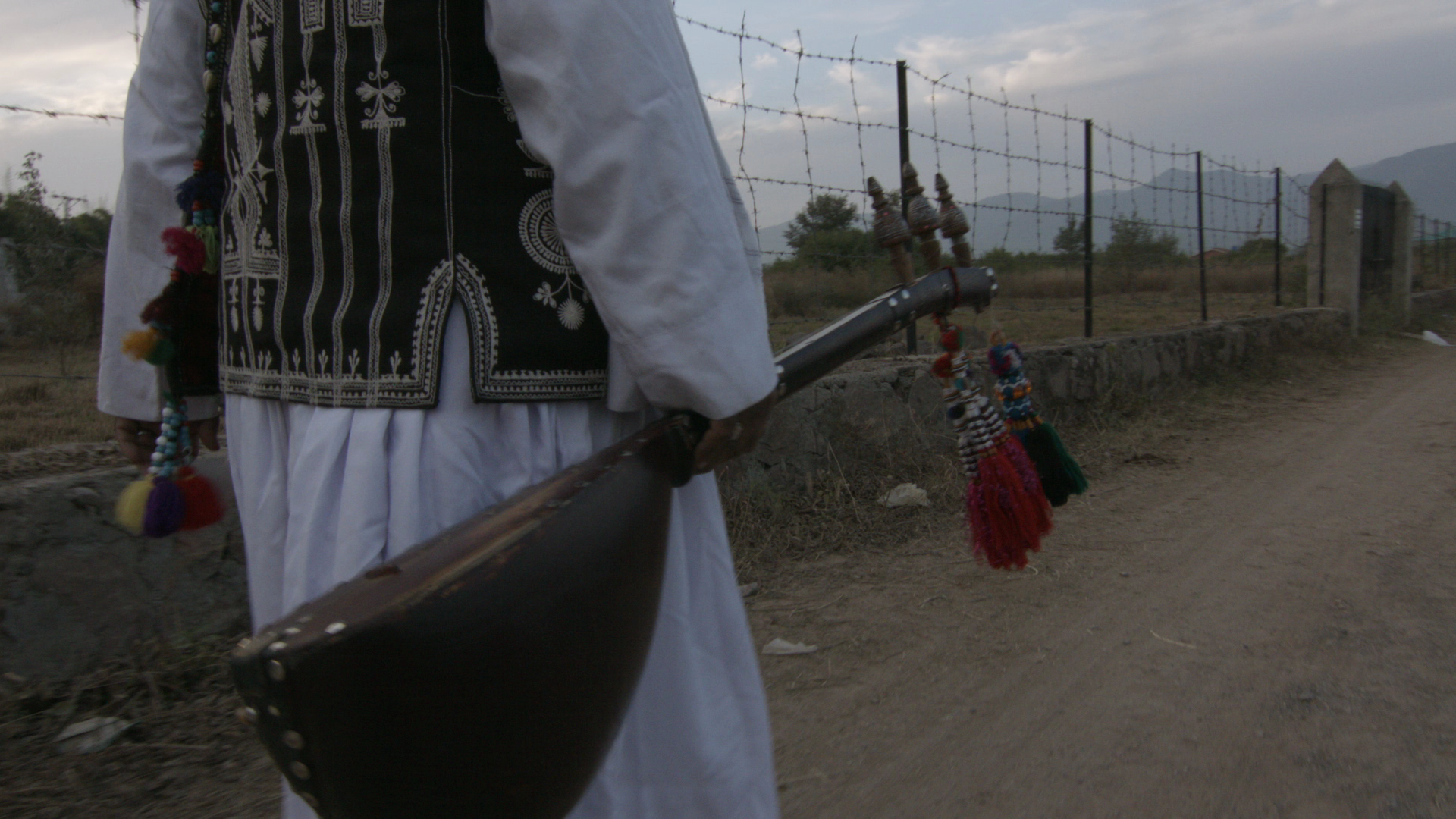 man holding a sitar while walking