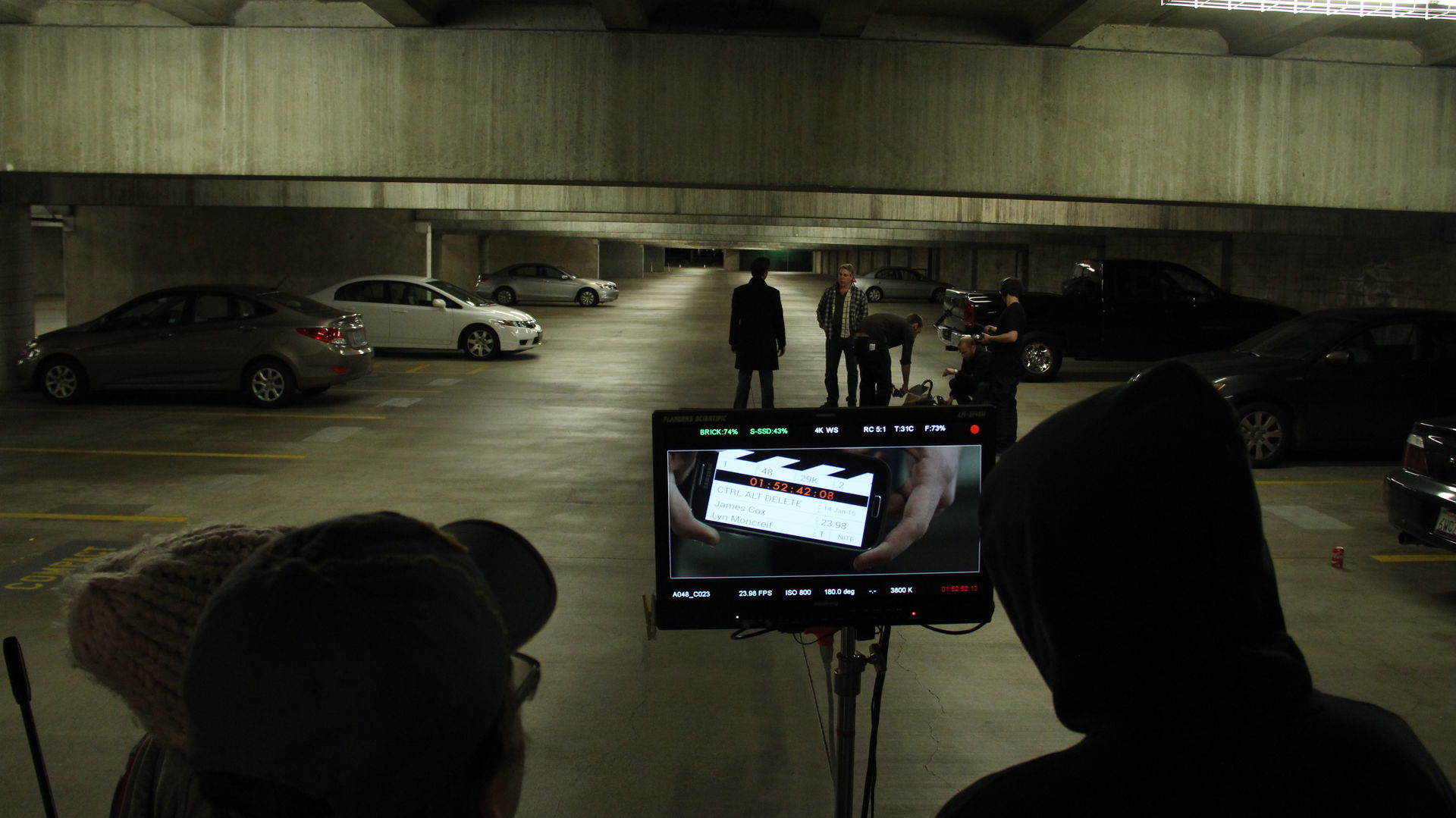 people behind a camera in a parking garage