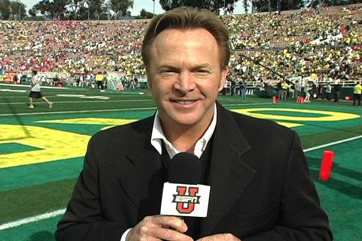 man holding microphone standing on football field