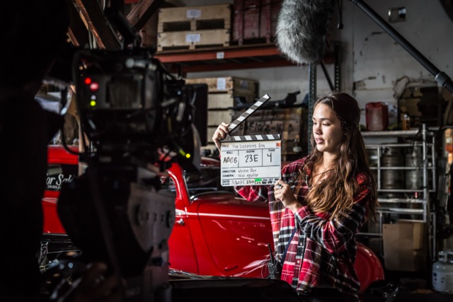 woman on a film setting holding a slate