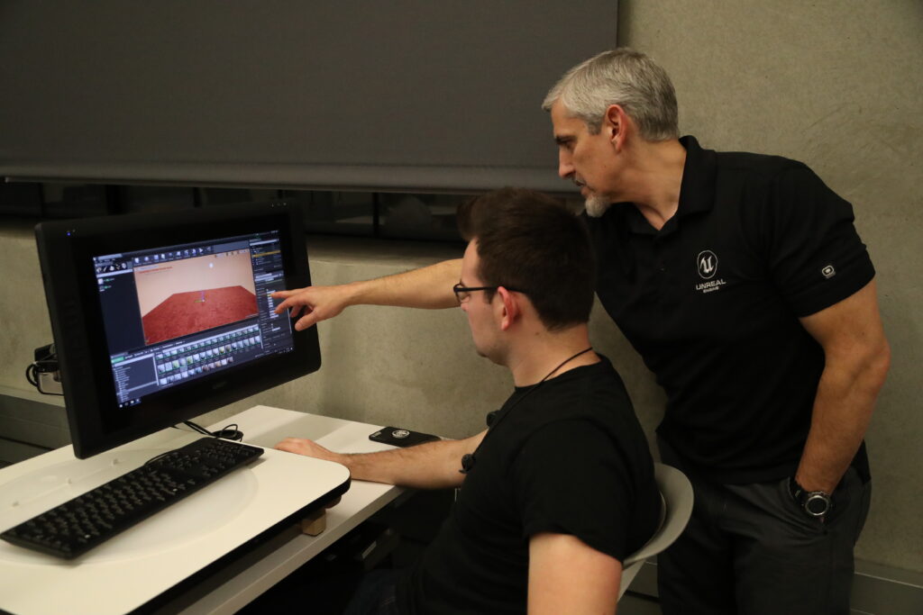 Professor and student at a computer in a virtual reality workshop
